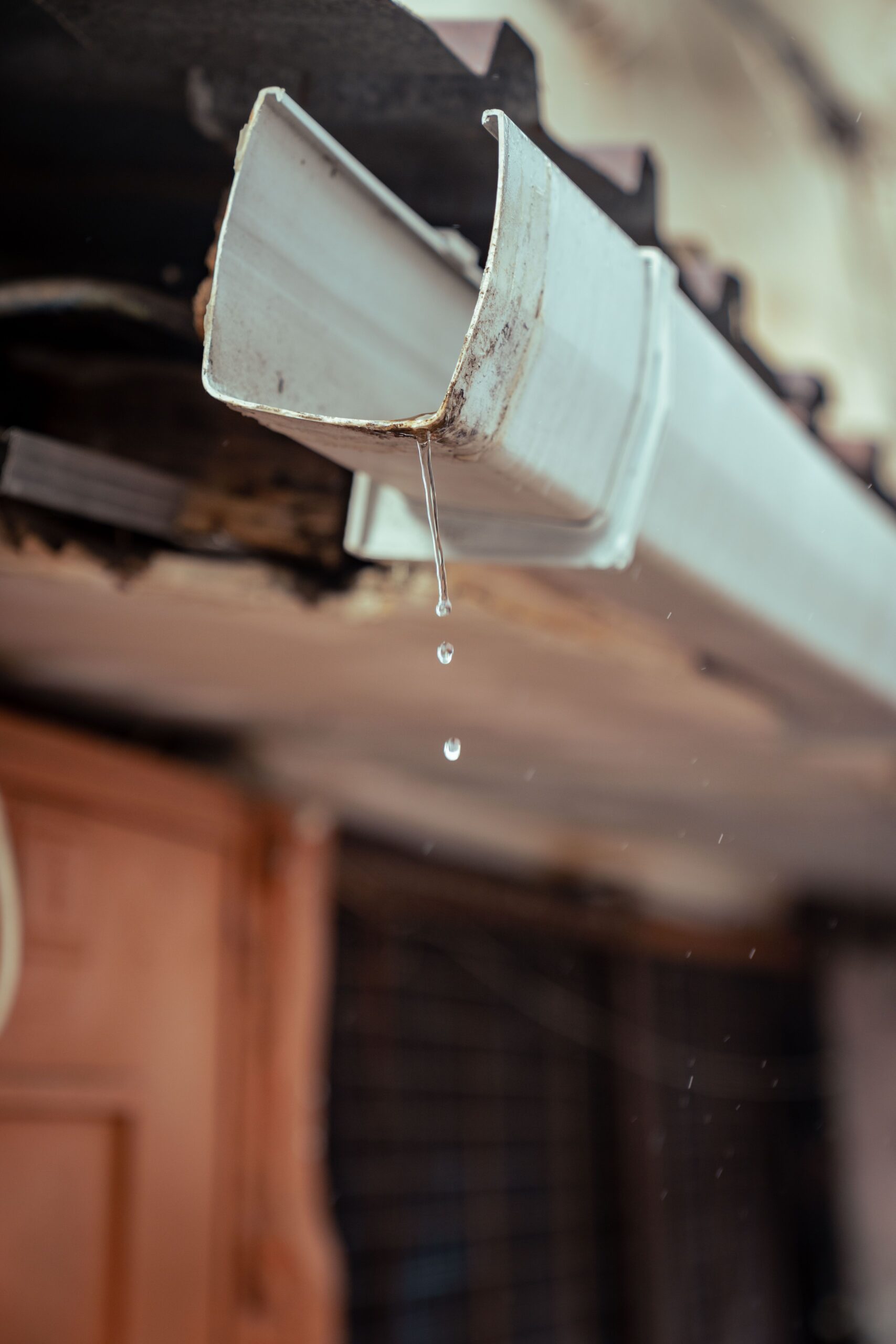 Water overflowing from a blocked gutter, a common sign gutter repair is needed