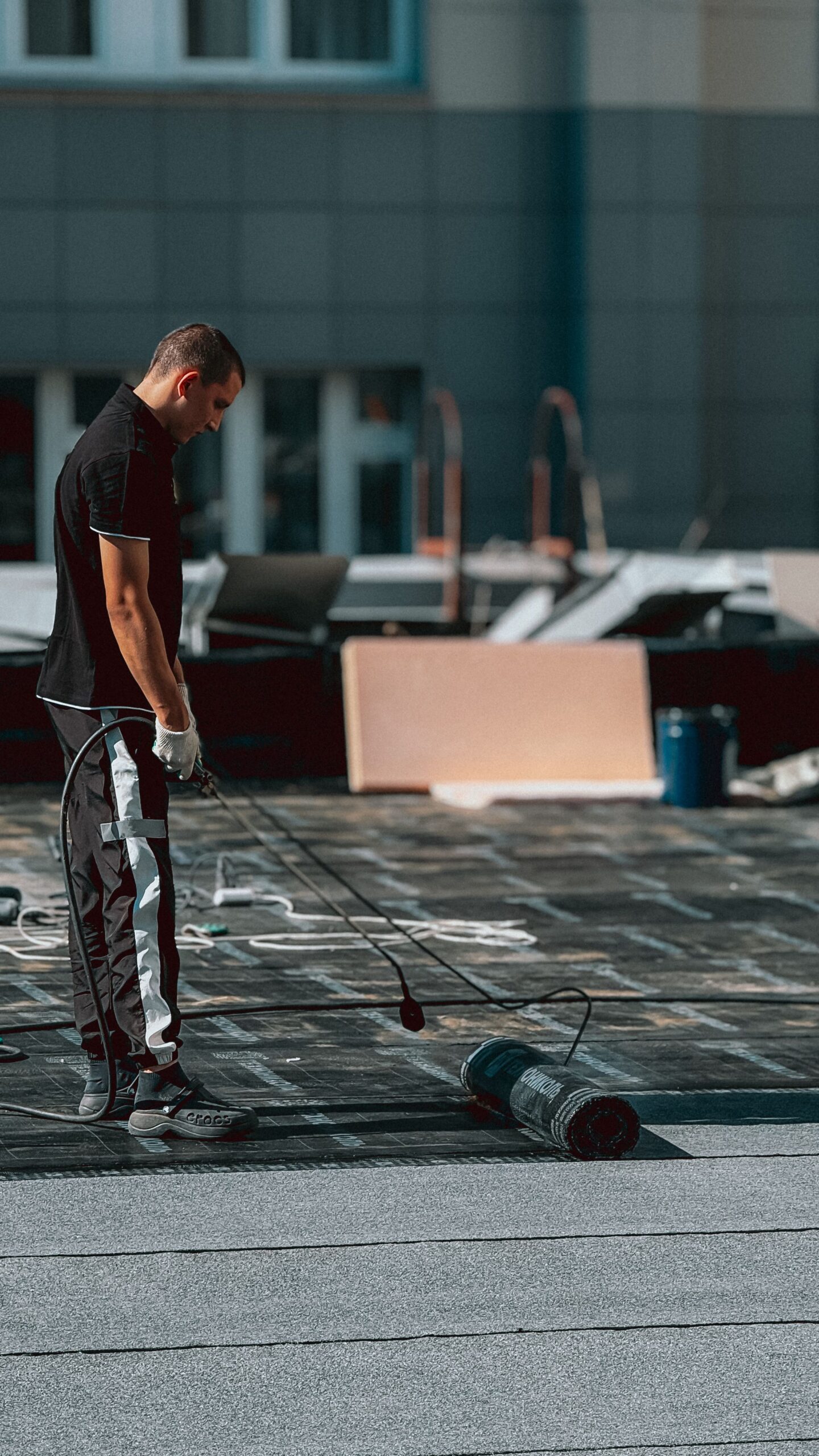 Roofer applying a waterproof GRP coating covered by a roof guarantee
