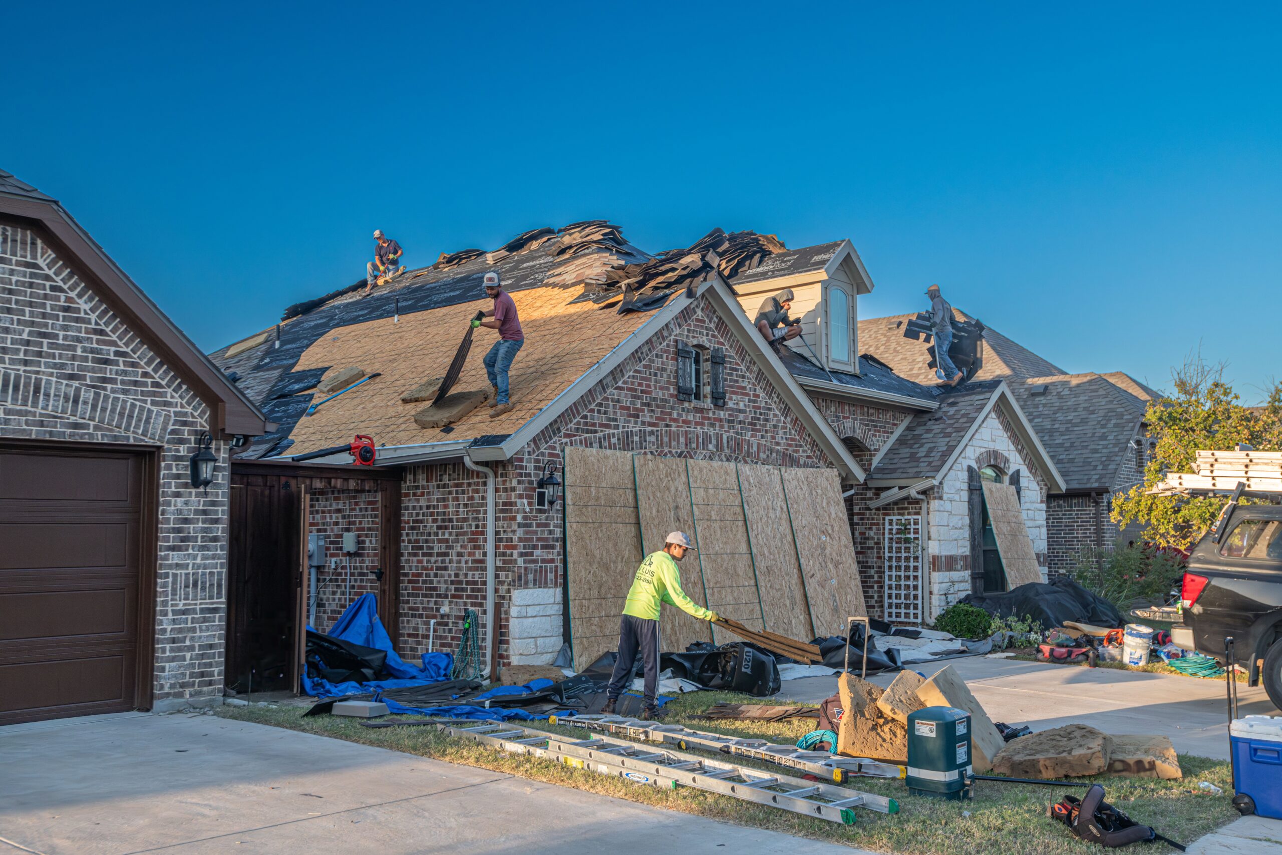 Roof replacement cost example: roofers fitting new tiles on a UK house